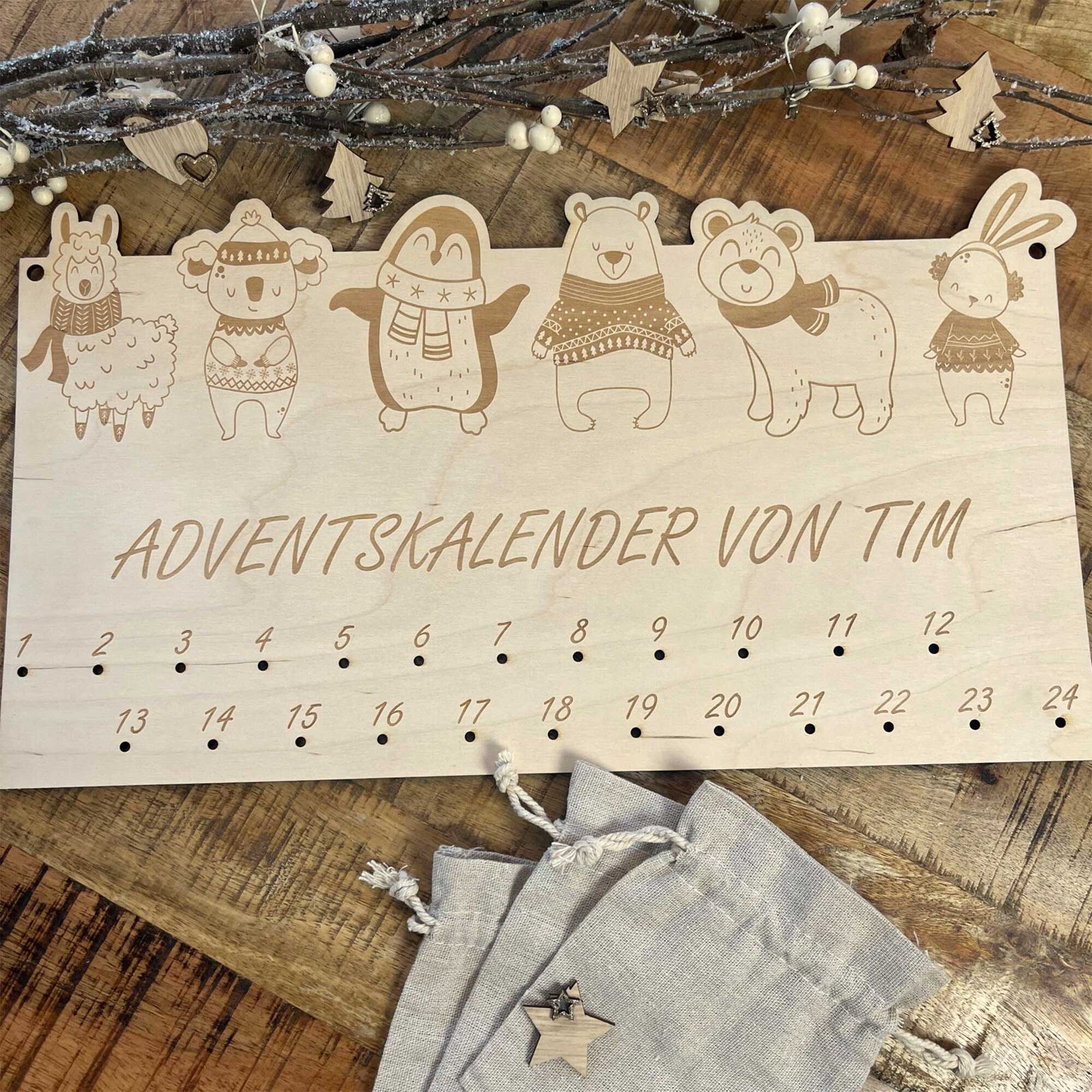 Adventskalender Holz mit Tiermotiven und Namen, dekorativ auf Holztisch mit Jutesäckchen – Adventskalender personalisiert zum Befüllen