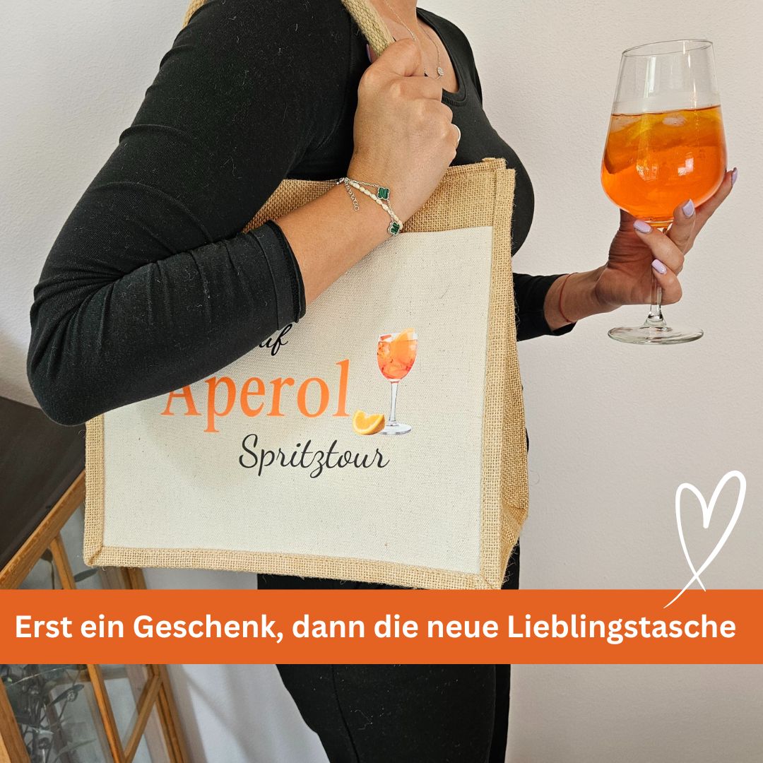 Frau mit Glas Aperol und passender Geschenk-Jutetasche – perfekte Geschenkidee für Mädelsabend