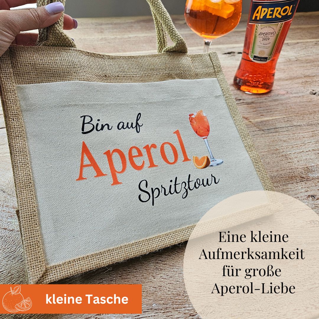 Kleine Aperol Tasche mit Spruch, daneben Aperolflasche – perfekte Geschenkidee