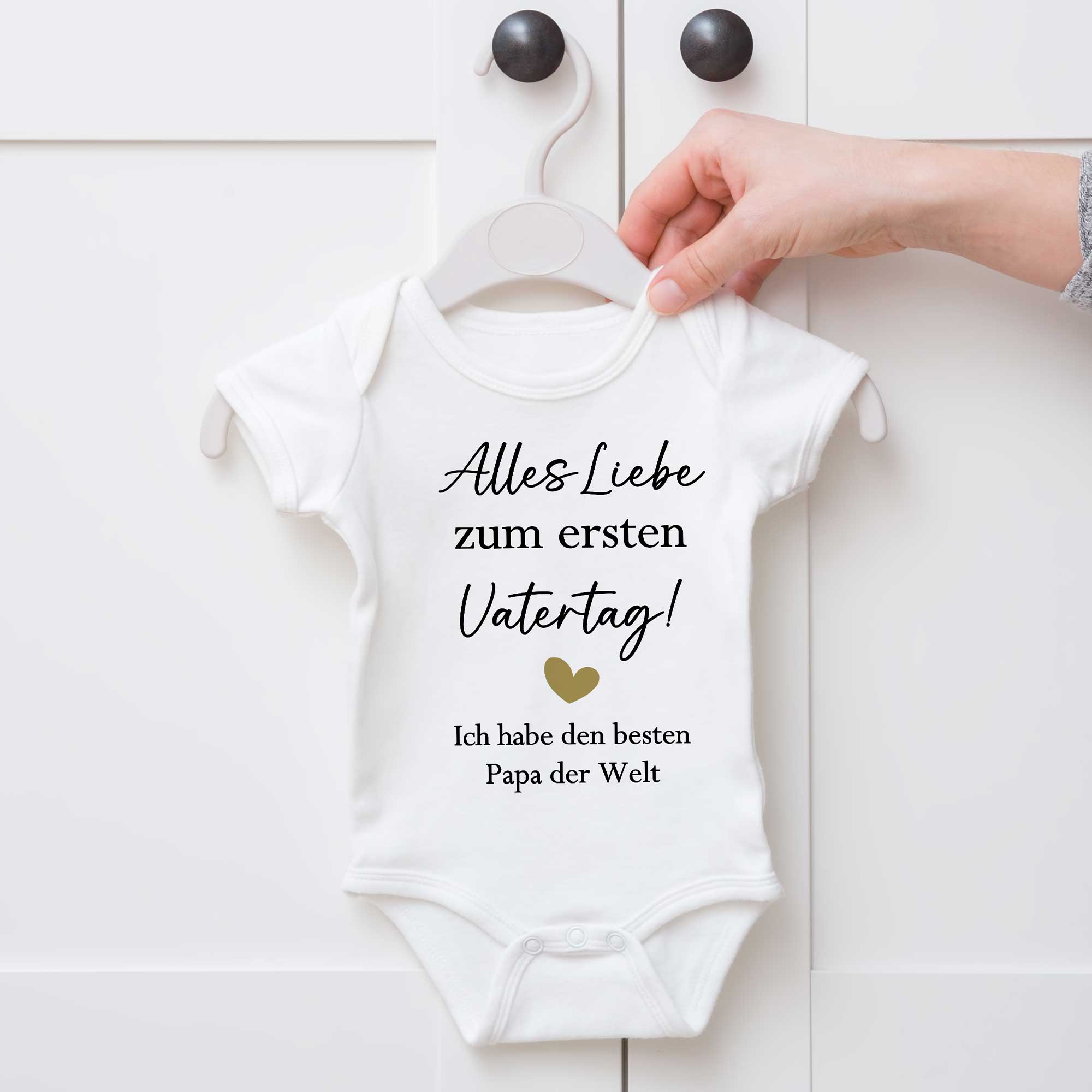 Baby Body mit Vatertagsmotiv an einem weißen Schrank aufgehängt – Geschenkidee für Papa