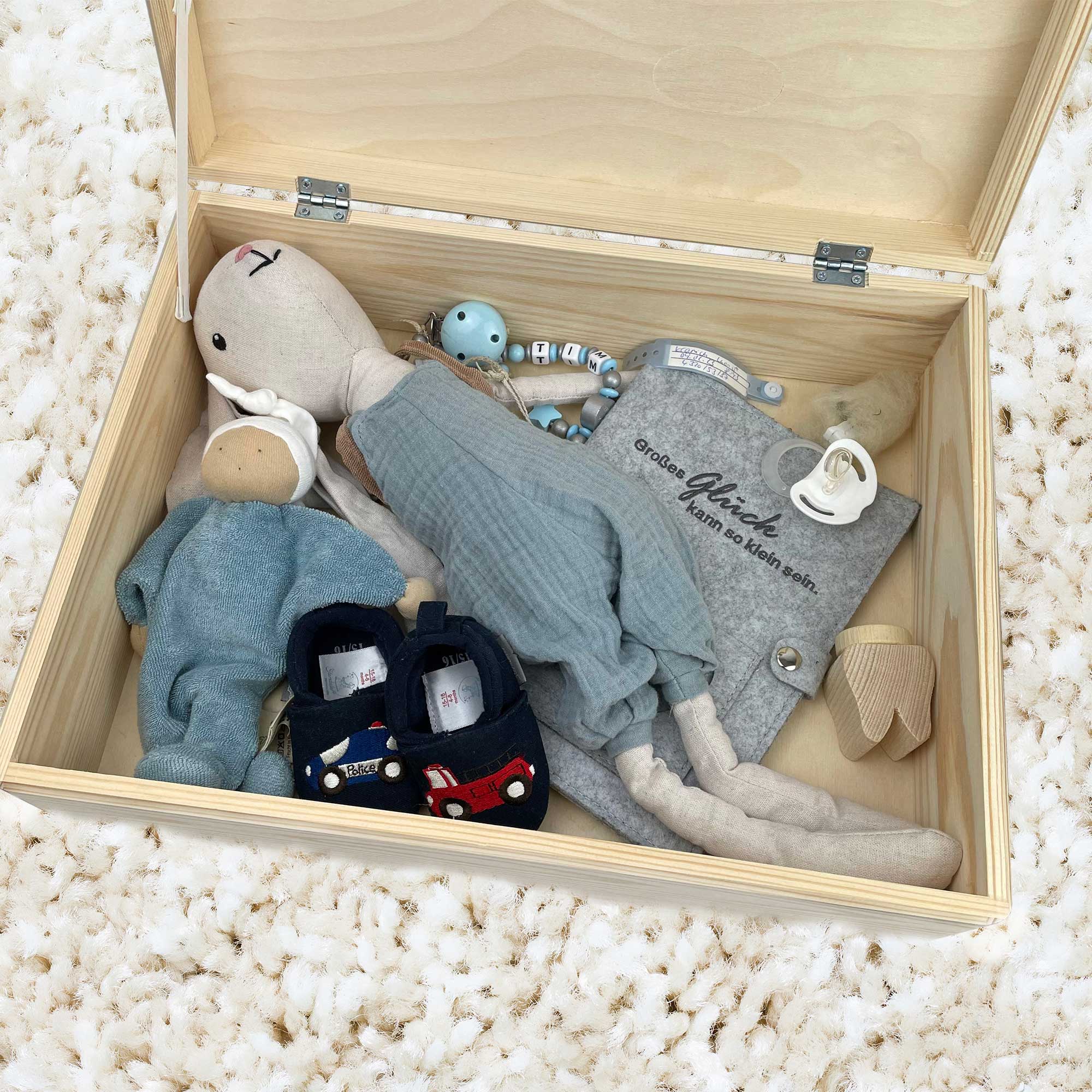 Große Baby Erinnerungskiste mit persönlichen Gegenständen wie Kuscheltier und Babyschuhen