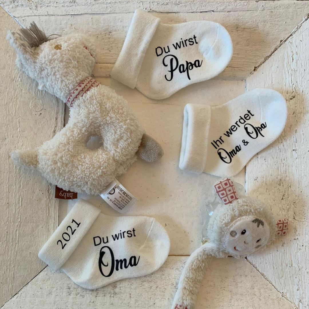 Drei personalisierte Babysocken mit Aufdruck zur Verkündung der Schwangerschaft