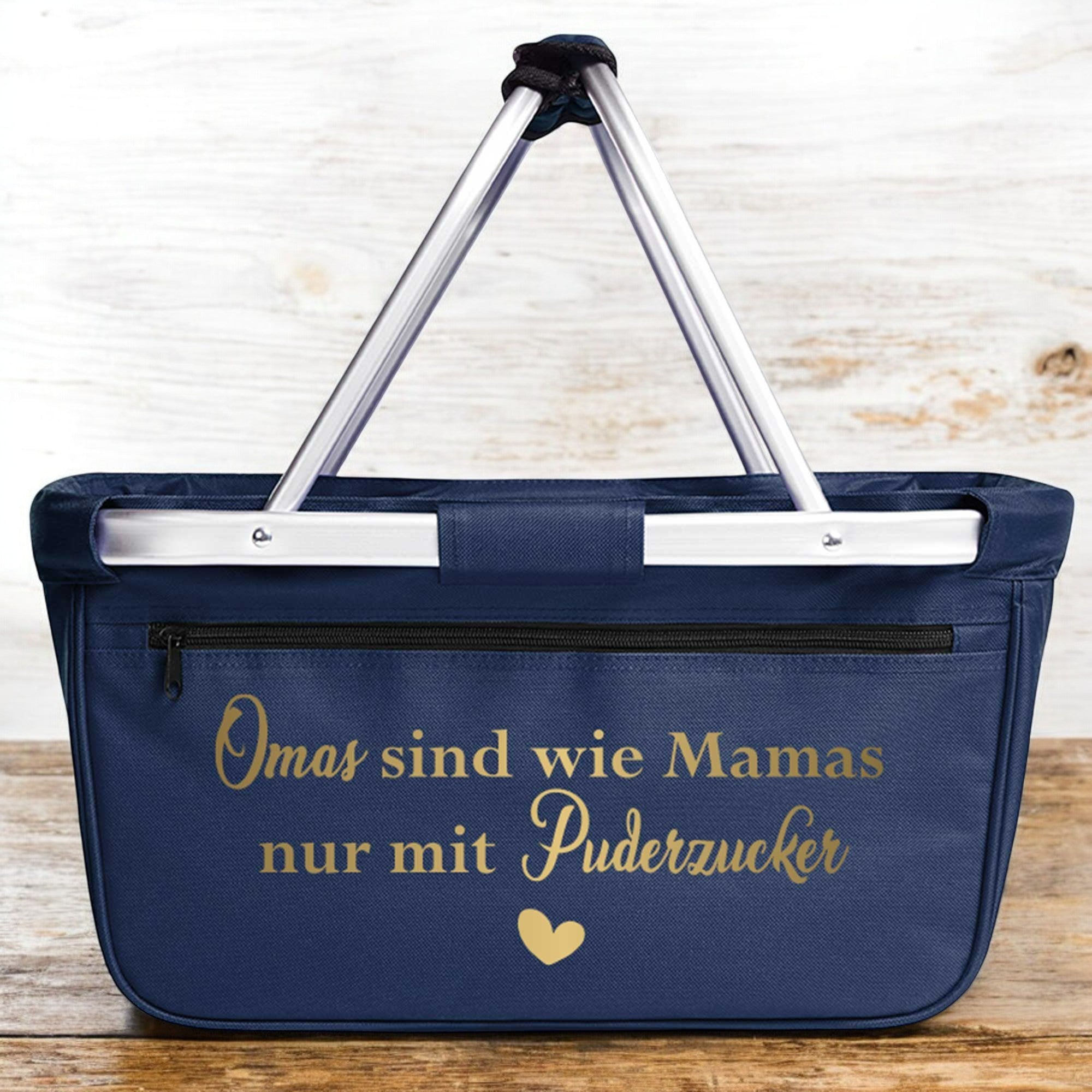Blauer Einkaufskorb mit goldener Aufschrift Omas sind wie Mamas nur mit Puderzucker vor Holz-Wand