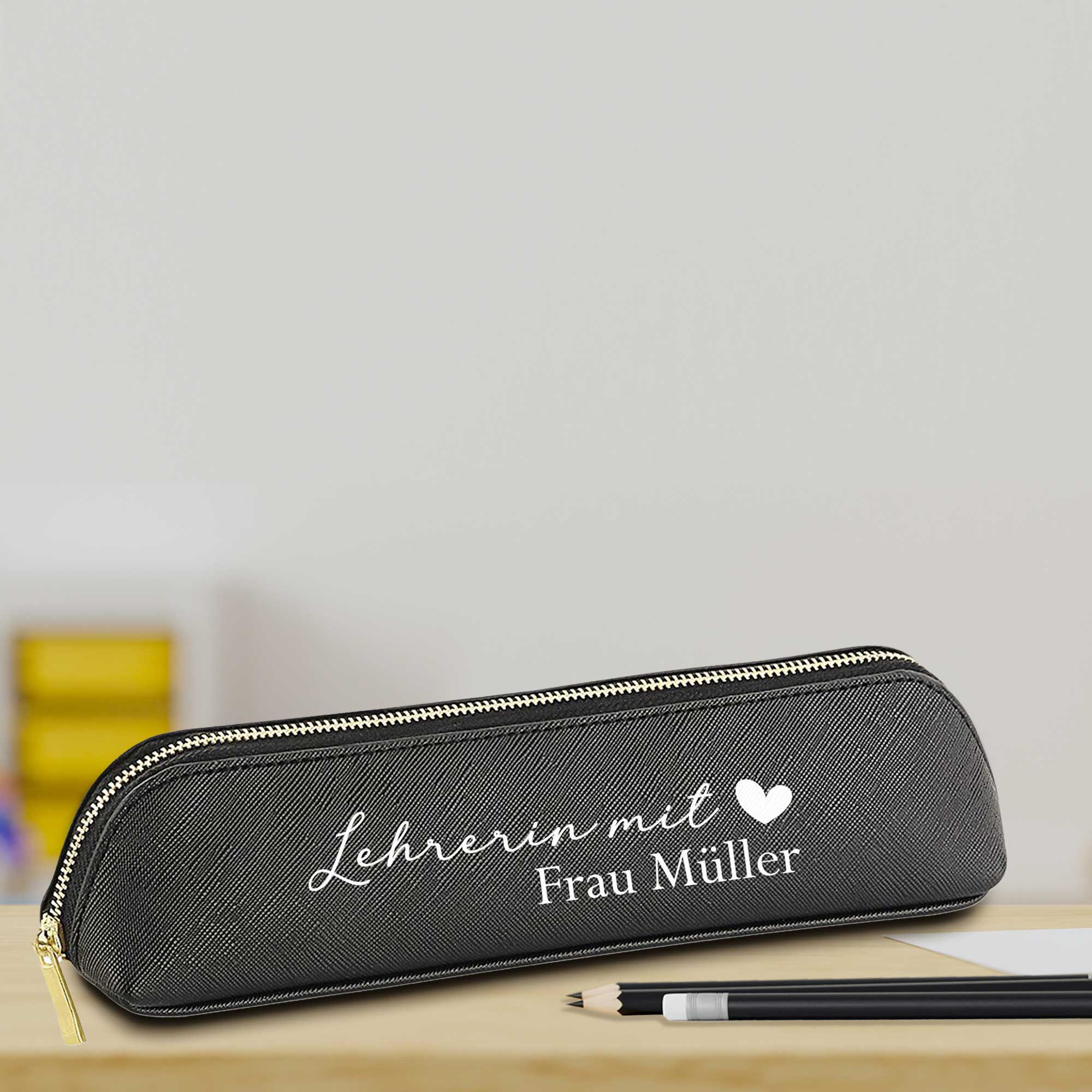Federmäppchen 'Lehrerin mit Herz' in Schwarz – Szene auf dem Schreibtisch mit Stiften