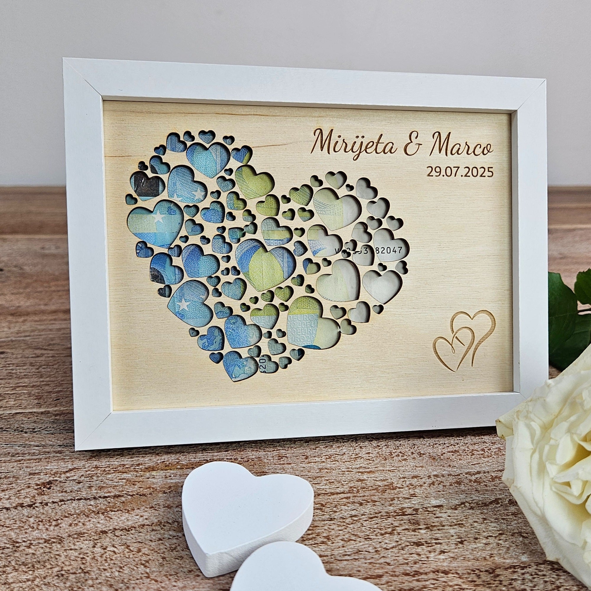 Geldgeschenk zur Hochzeit im weißen Bilderrahmen mit Herz aus kleinen Holzherzen und Geldscheinen