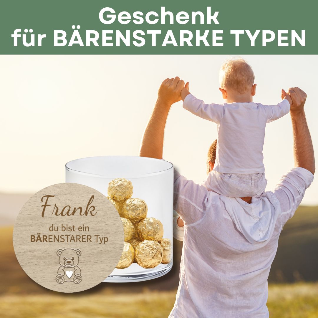 Vater trägt Kind auf den Schultern mit Geschenkglas im Vordergrund
