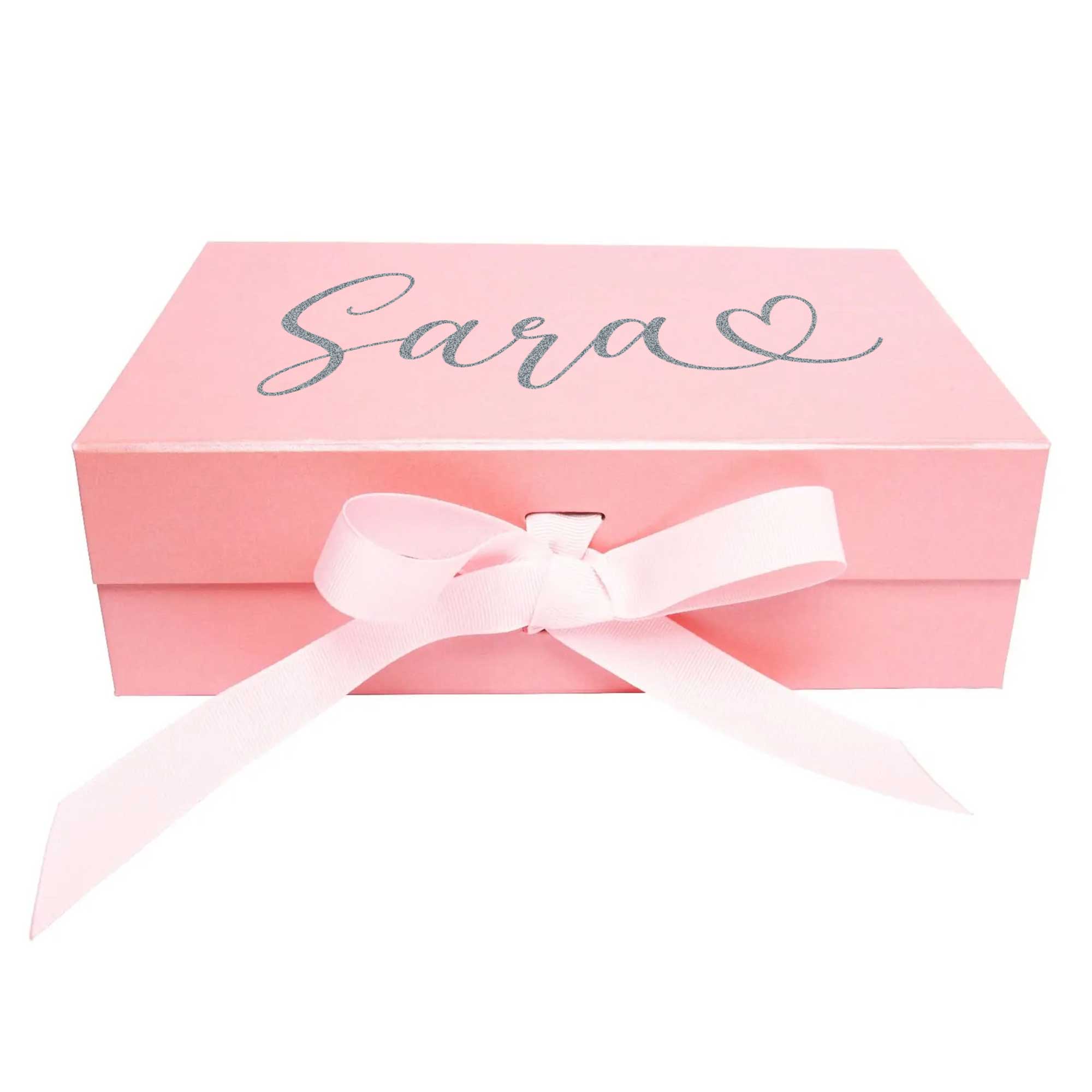 Freigestellte rosa Geschenkbox mit Schleife und Namensaufdruck