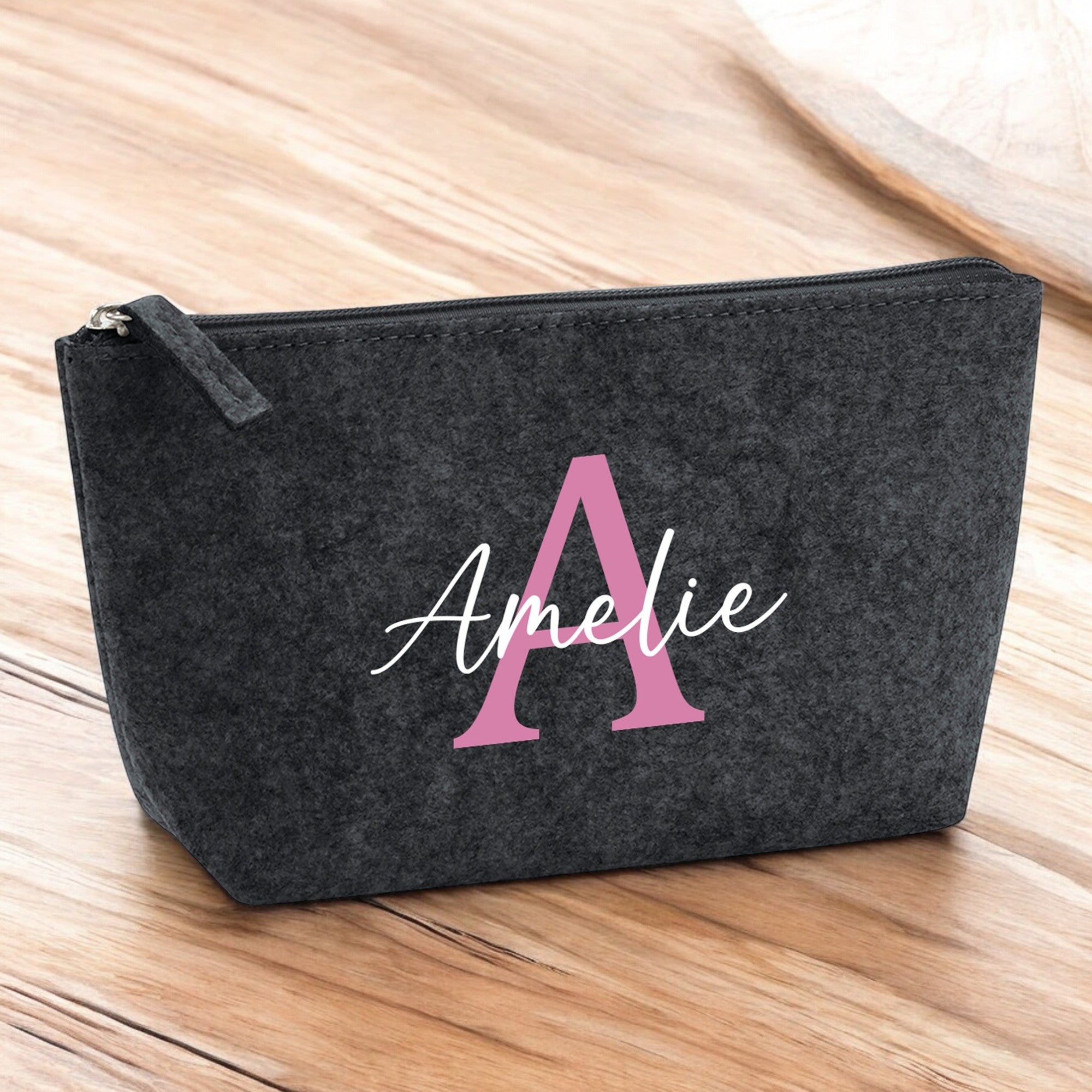 Kleine Kosmetiktasche aus Filz in Anthrazit mit personalisiertem Namen auf Holztisch