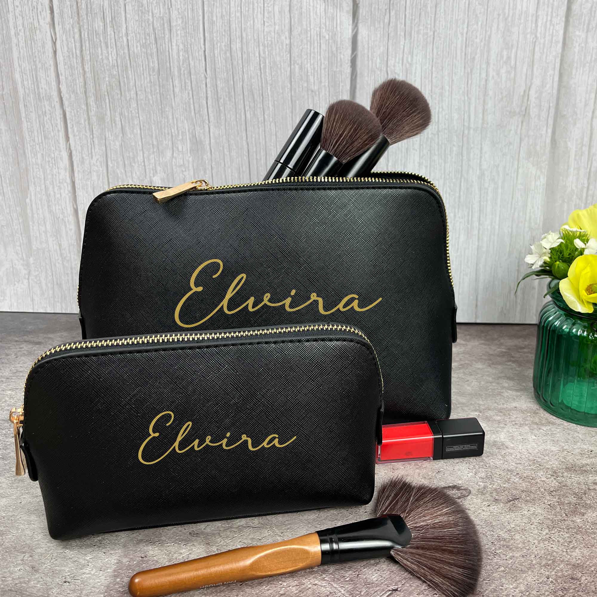 Zwei schwarze Kosmetiktaschen mit Namen Elvira, gefüllt mit Make-up Pinseln
