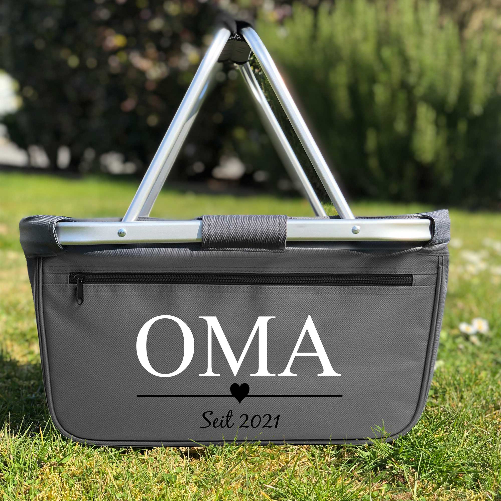 Anthrazitfarbener Einkaufskorb personalisiert mit 'Oma seit 2021' auf der Wiese