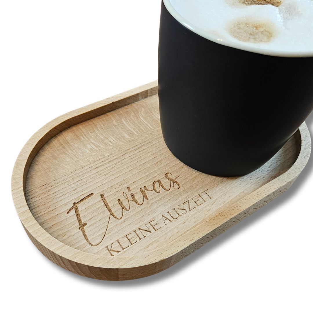 Nahaufnahme eines gravierten Tabletts mit dem Namen Elvira und einer schwarzen Kaffeetasse