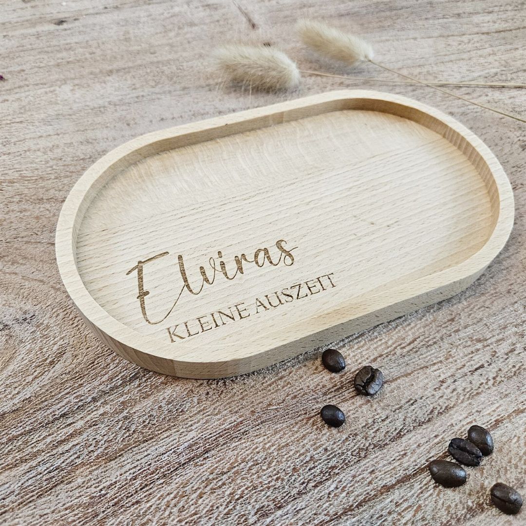 Graviertes Tablett mit dem Namen Elvira und dem Text 'kleine Auszeit' auf einem Holztisch mit Kaffeebohnen