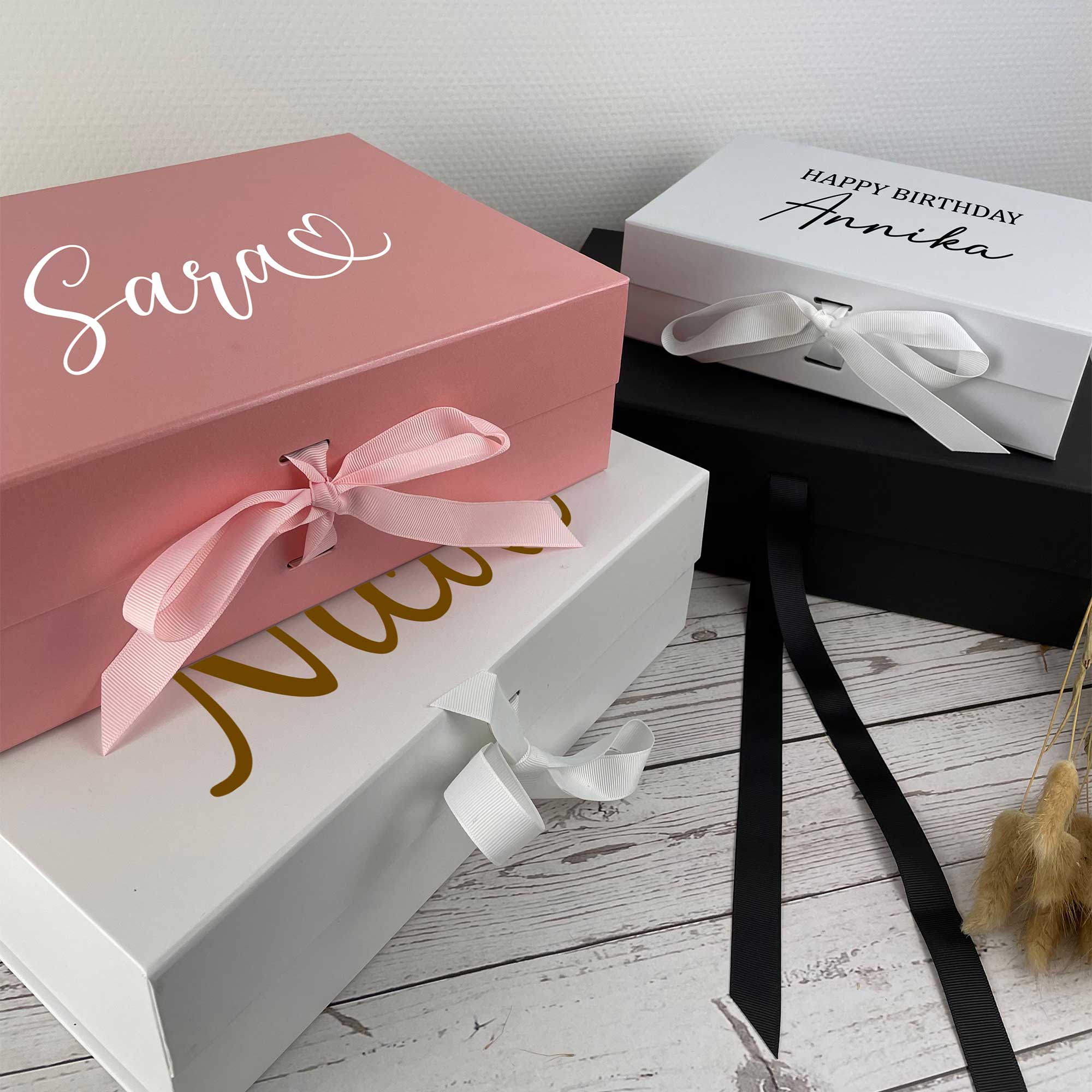 Verschiedene Geschenkboxen mit Namensgravur in mehreren Farben