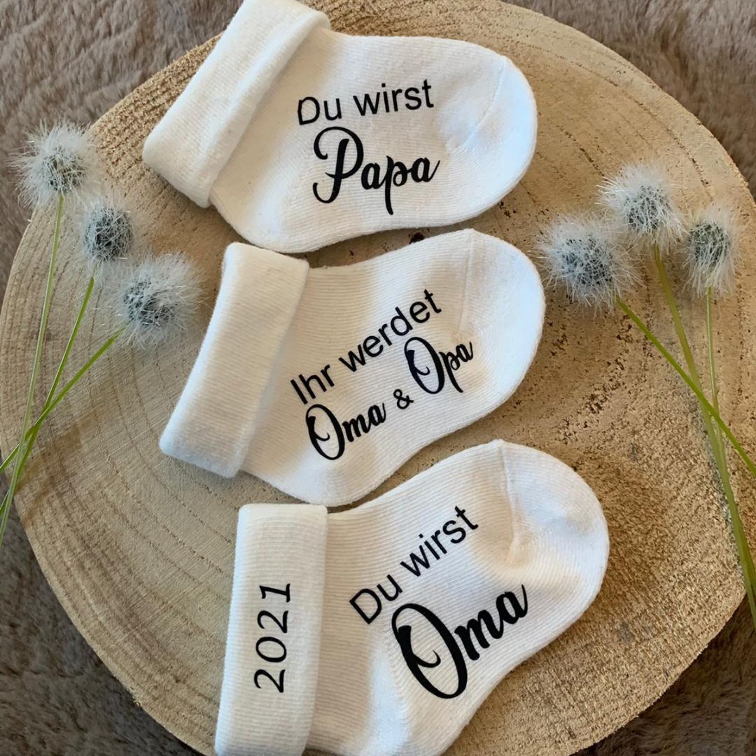 Schwangerschaftsverkündung mit Babysocken und Ultraschallbild als emotionale Geschenkidee