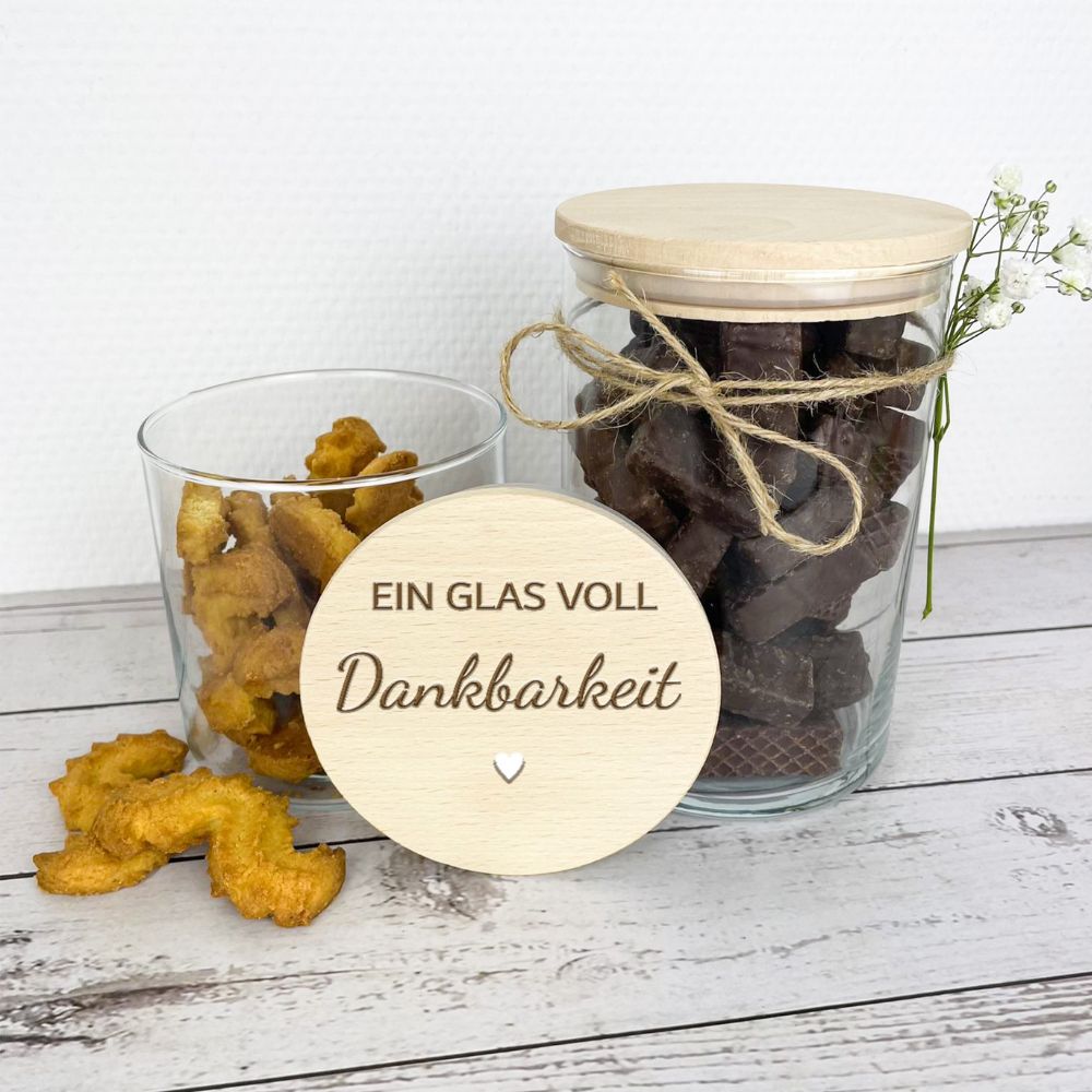 Zwei Gläser mit Keksen und Waffeln, im Vordergrund der gravierte Deckel mit Dankbarkeitsspruch