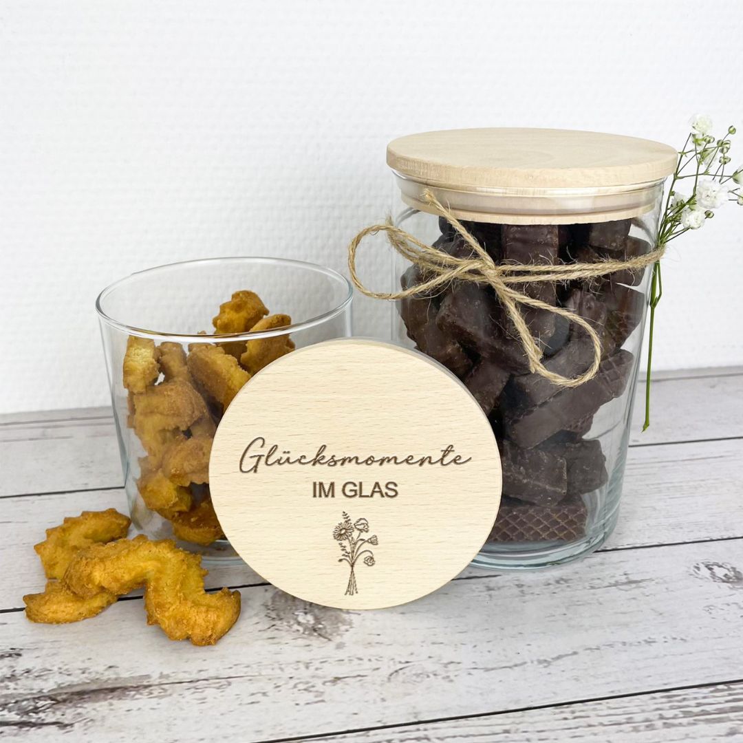 Zwei Vorratsgläser mit Holzdeckel, gefüllt mit Keksen und Schokolade, Gravur ‚Glücksmomente im Glas‘