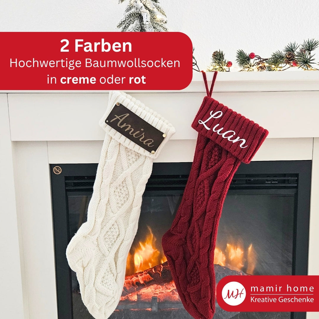 Zwei Weihnachtsstrümpfe aus Strick in Rot und Creme mit verschiedenen Personalisierungen vor Kamin