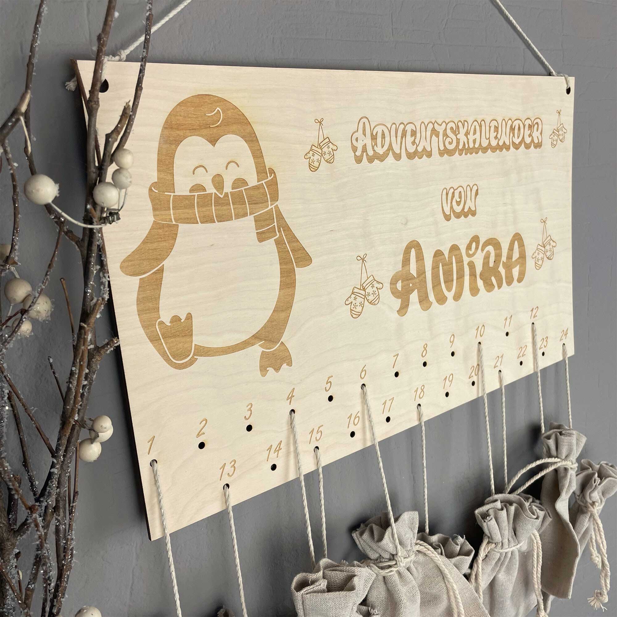DIY Adventskalender Kinder aus Holz im Pinguin-Design, schräg an der Wand hängend