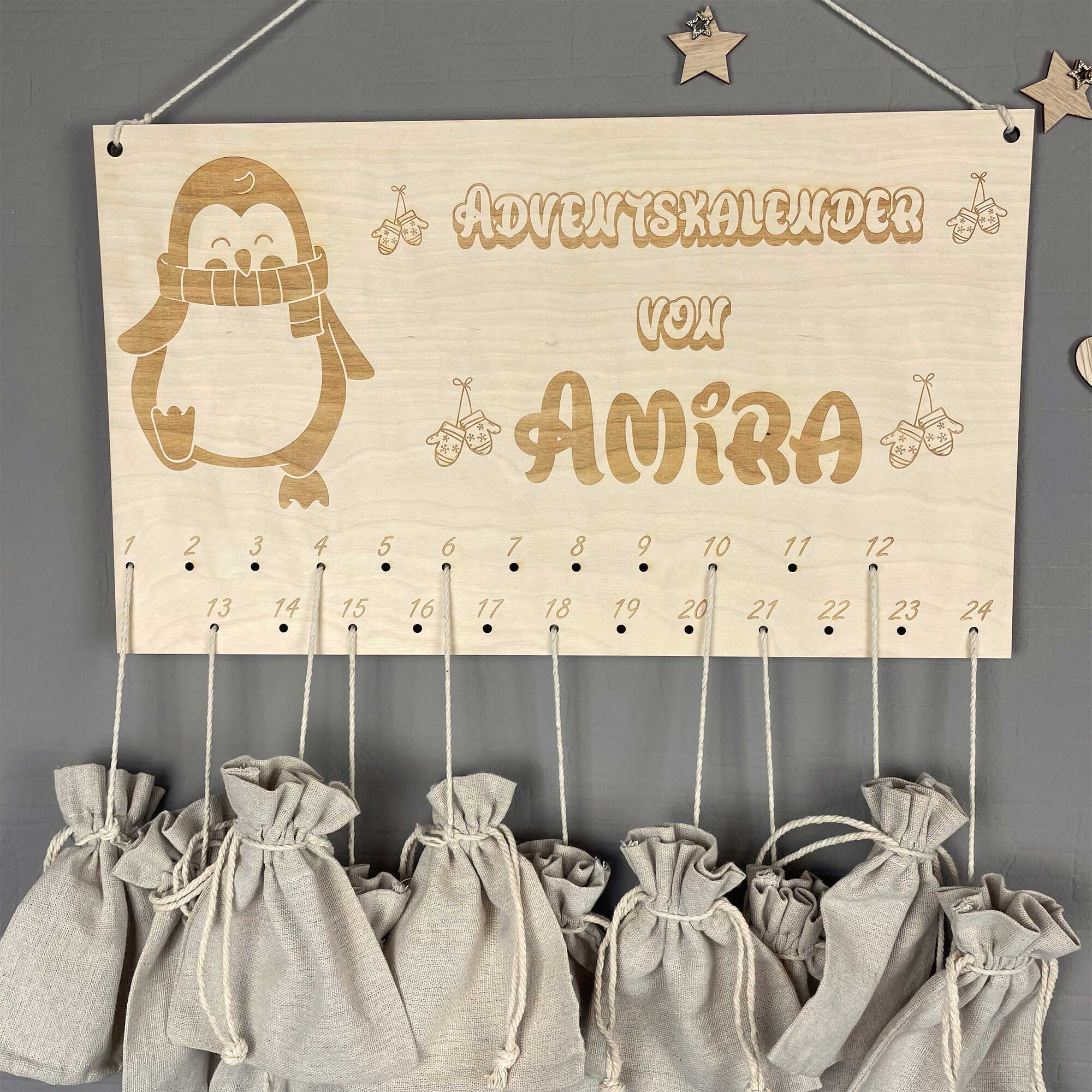 Personalisierter Adventskalender Holz Pinguin mit Namen, dekoriert an der Wand