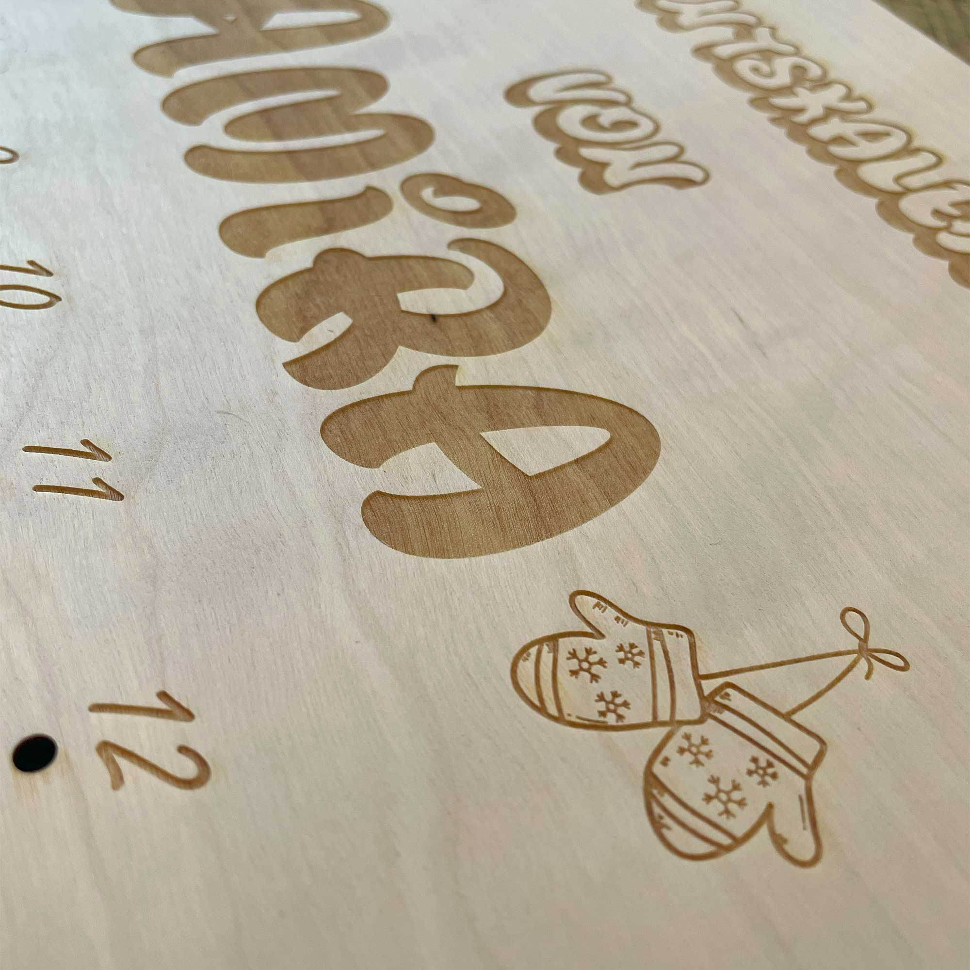 Detailaufnahme personalisierter Adventskalender Holz mit Gravur Pinguin und Namen