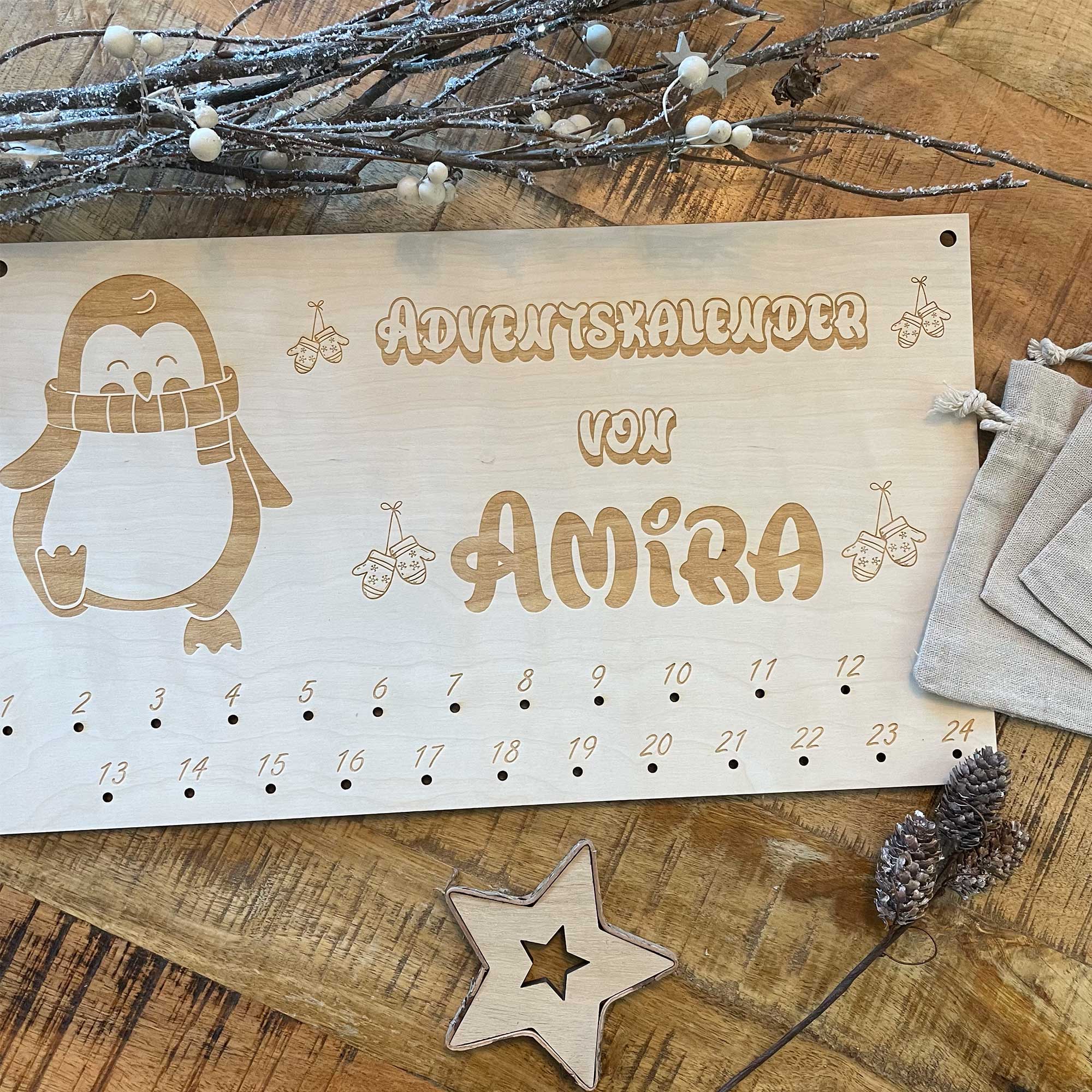 Personalisierter Adventskalender Holz Pinguin mit Jutesäckchen auf Holztisch dekoriert