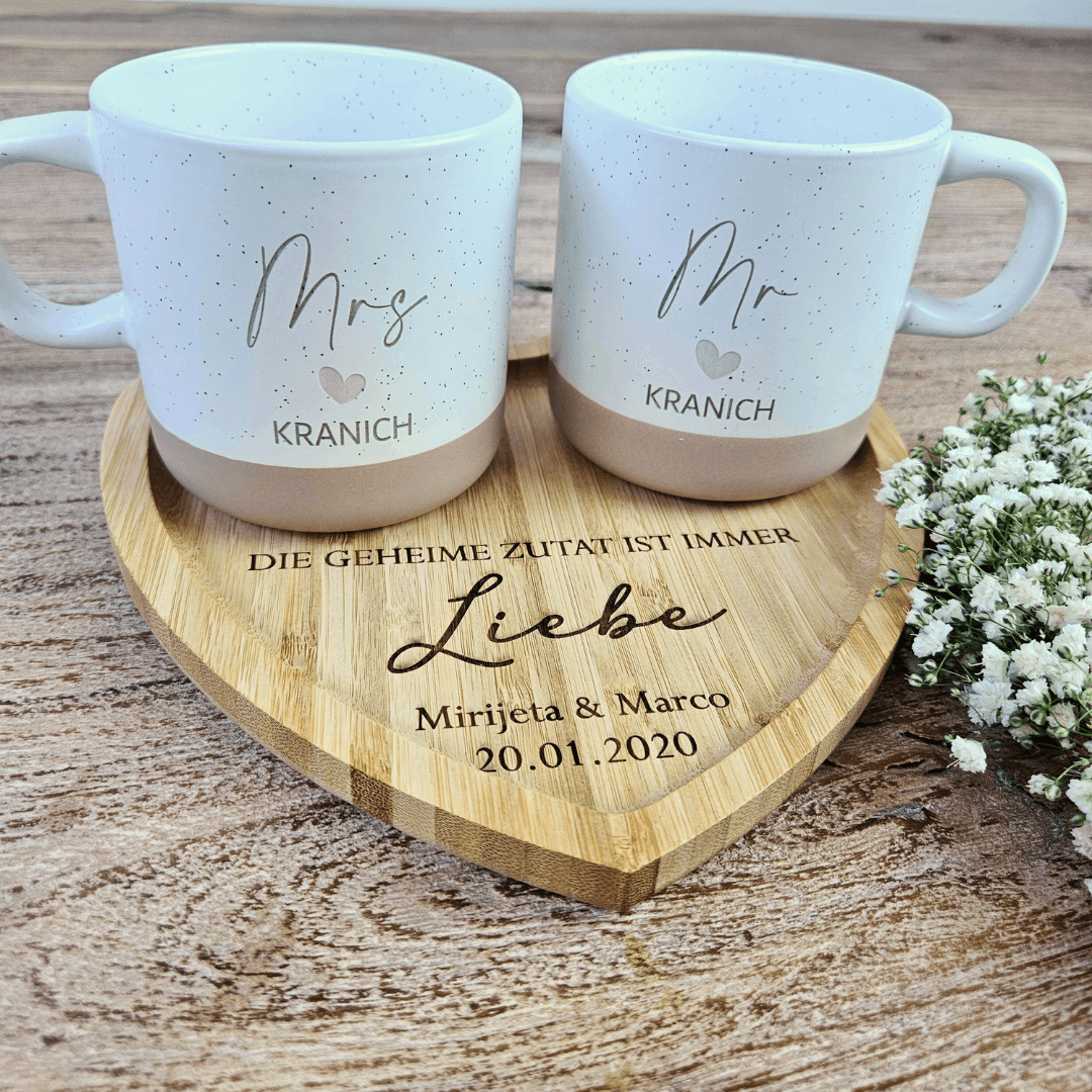 Zwei personalisierte Steingut Tassen Mr und Mrs mit Nachnamen auf graviertem Herz-Tablett aus Holz. Liebevolles Hochzeitsgeschenk für Paare, perfekt für den ersten Kaffee als Ehepaar.