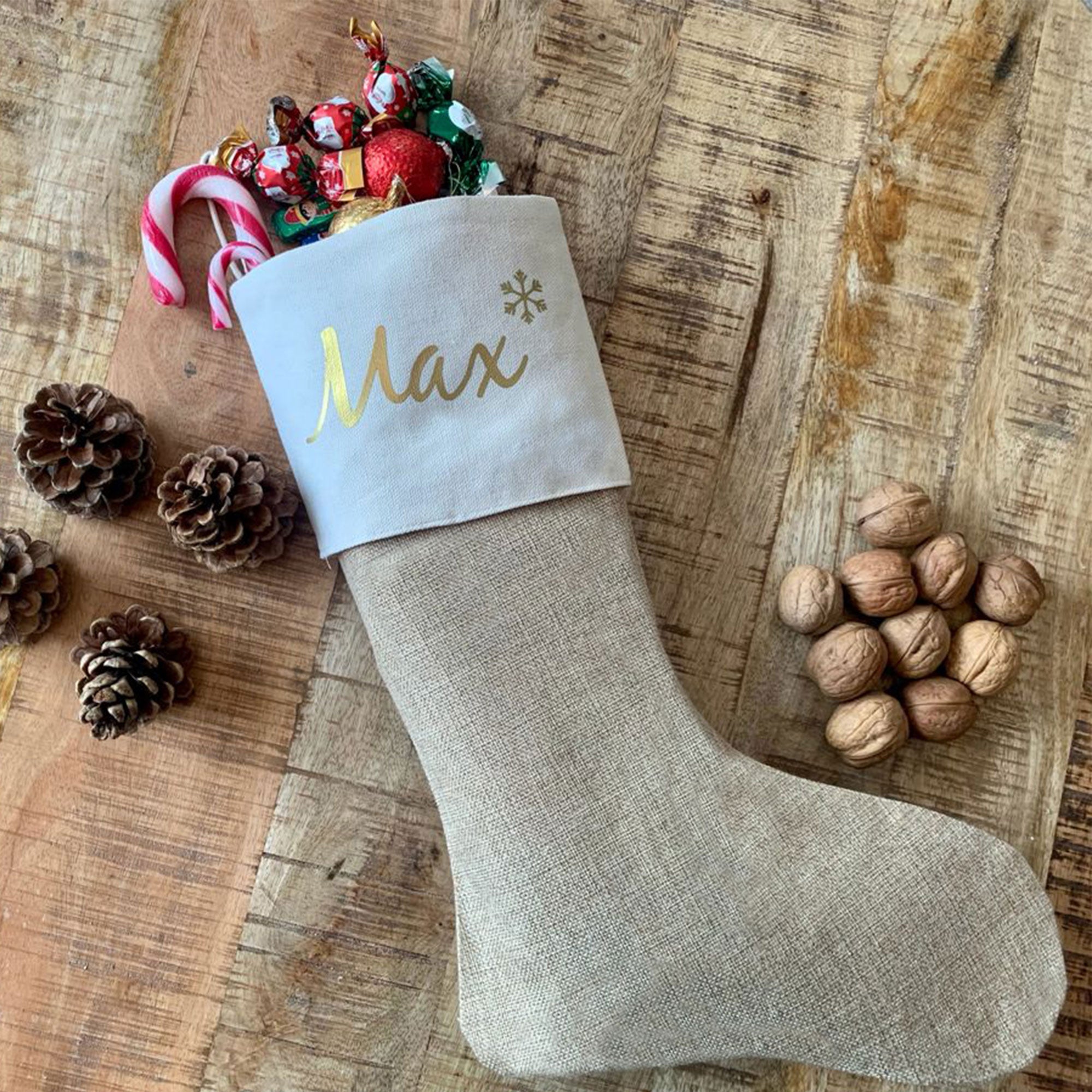Nikolausstiefel mit Name Max, gefüllt mit Schokolade und Zuckerstange, dekoriert mit Nüssen und Tannenzapfen