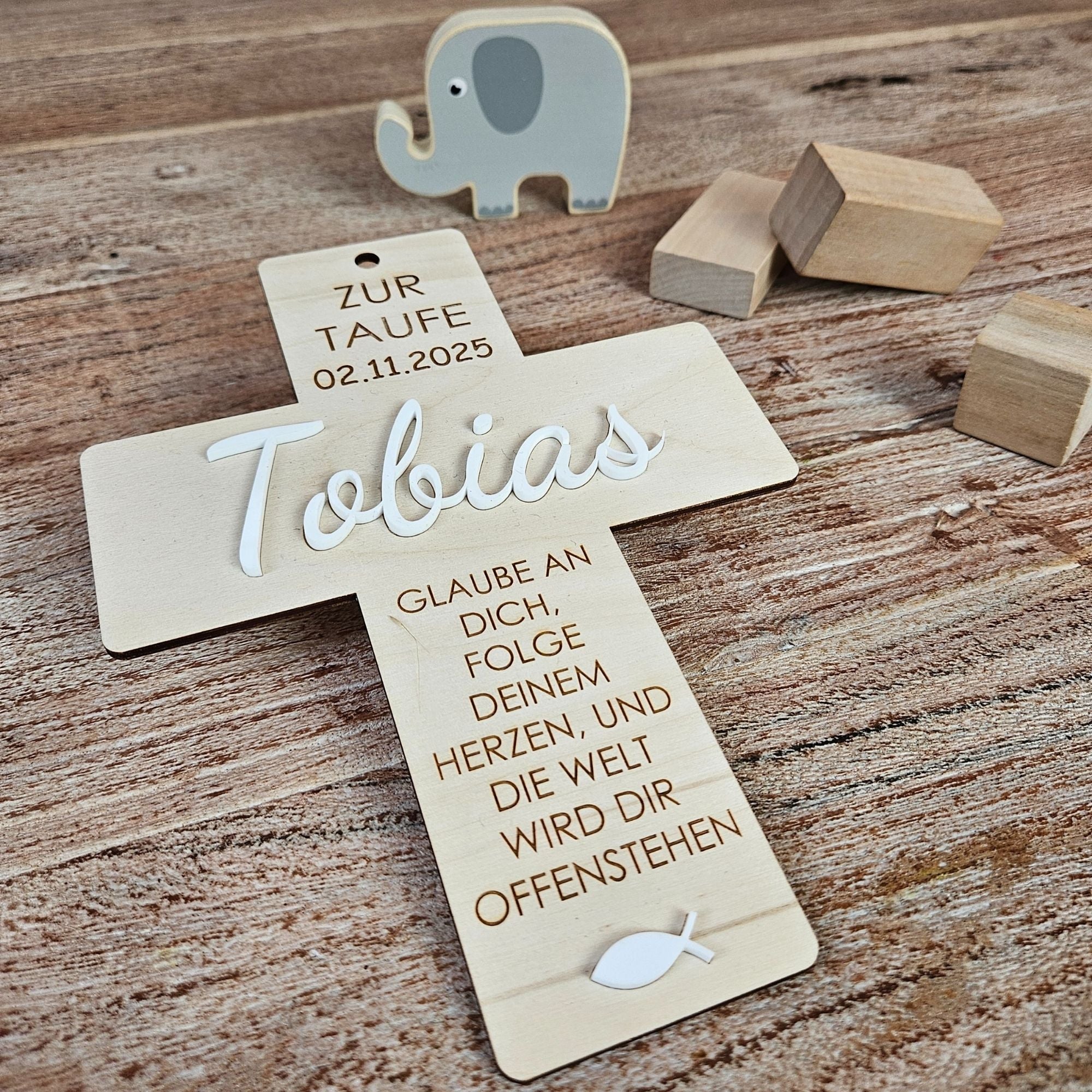 Taufgeschenk aus Holz mit 3D-Name und 3D-Fisch, schraeg fotografiert auf Holztisch